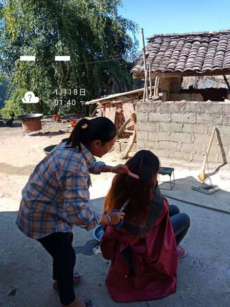 哲语为贫困户修剪长发